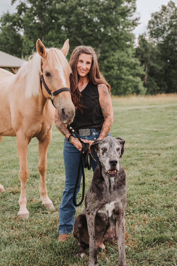 Becca in the pasture with a palomino horse and the farm's Great Dane